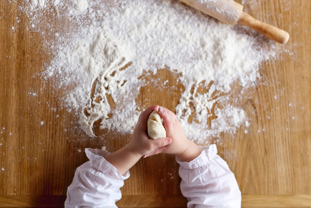 Child's hands playing with the flour